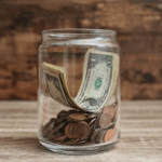 US dollars and cents in a jar on a counter