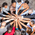 adults of various ethnic orgins with hands all in a circle together